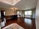 Open-concept dining and living room area featuring hardwood floors and a decorative chandelier at 3579 Maple Ridge Loop, Kissimmee, FL 34741