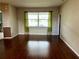 Bright living room features beautiful hardwood floors, large windows, and green curtains at 3579 Maple Ridge Loop, Kissimmee, FL 34741