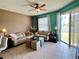 Bright living room with tile flooring, neutral decor, and sliding glass doors to the patio at 3579 Maple Ridge Loop, Kissimmee, FL 34741