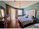 Comfortable bedroom featuring a decorative headboard, hardwood floors, and ample natural light at 3579 Maple Ridge Loop, Kissimmee, FL 34741