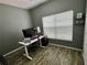 Office with gray walls, laminate flooring, a white desk, and a large window for natural light at 3579 Maple Ridge Loop, Kissimmee, FL 34741