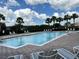 Sparkling pool with lounge chairs and palm trees offers a refreshing oasis for relaxation and enjoyment at 3579 Maple Ridge Loop, Kissimmee, FL 34741