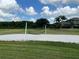 A community sand volleyball court is set against a backdrop of lush green space and blue skies, perfect for outdoor fun at 3579 Maple Ridge Loop, Kissimmee, FL 34741
