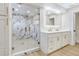 Bright bathroom featuring double sinks, white cabinets, gold hardware, and a walk-in shower with beautiful tile at 40 W Laurel St, Apopka, FL 32703