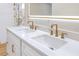 Bathroom vanity featuring white cabinets, double sinks, quartz countertop, gold hardware, and a lighted mirror at 40 W Laurel St, Apopka, FL 32703