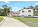 Exterior view of white two-story home with lush landscaping and a circular driveway at 40 W Laurel St, Apopka, FL 32703