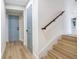 Hallway featuring a wooden staircase with white risers, a hallway closet, and blue accent door at 40 W Laurel St, Apopka, FL 32703