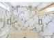 Shower featuring dual shower heads, a river stone floor, and white marble walls with gold trim accents at 40 W Laurel St, Apopka, FL 32703