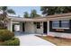 Charming front exterior with a covered parking area and meticulously landscaped surroundings at 4015 Kirkland Blvd, Orlando, FL 32811