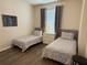 Guest bedroom with grey bedding, wood floor, and natural light at 4024 Breakview Dr # 40604, Orlando, FL 32819