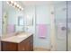 Bright bathroom featuring a glass-enclosed shower with tan colored tile and a single sink with a granite countertop at 4216 Cricket Hollow Cv, Casselberry, FL 32707