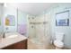 Bright bathroom featuring a glass-enclosed shower with tan colored tile, a single sink with a granite countertop at 4216 Cricket Hollow Cv, Casselberry, FL 32707