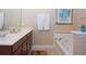 Bright bathroom featuring double sinks, soaking tub and neutral colors, decorated with matching flower art at 4405 Acorn Ct, Davenport, FL 33837