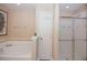 Bright bathroom featuring a shower, a tub, and a door, perfect for relaxation and functionality at 4405 Acorn Ct, Davenport, FL 33837