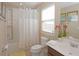 Bathroom features a window, a toilet, a sink, a tub with shower and towels at 4405 Acorn Ct, Davenport, FL 33837