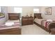 Cozy bedroom featuring two beds, a dresser, warm tones, and natural light, for comfortable living at 4405 Acorn Ct, Davenport, FL 33837