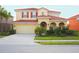 Charming two-story home featuring a red tile roof, neutral exterior, and a well-maintained front lawn at 4405 Acorn Ct, Davenport, FL 33837
