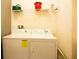 Functional laundry room with a washer, dryer, shelving, and storage space for household tasks at 4405 Acorn Ct, Davenport, FL 33837