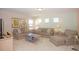 A spacious living room featuring neutral furniture and decor with natural light from the windows at 4405 Acorn Ct, Davenport, FL 33837