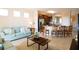 Cozy living room featuring a comfortable light-blue sofa and an open layout to the adjacent kitchen at 4405 Acorn Ct, Davenport, FL 33837