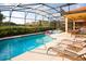 Stunning screened-in pool and spa with lounge chairs, offering a private outdoor oasis at 4405 Acorn Ct, Davenport, FL 33837