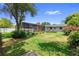 Spacious backyard with a screened-in pool, manicured lawn, and brick chimney at 4700 Larado Pl, Orlando, FL 32812