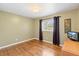 Bedroom with hardwood floors, a window and curtains, and a small TV on a dresser at 4700 Larado Pl, Orlando, FL 32812