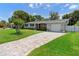Beautiful home with a brick-paved driveway leading to an attached garage, and lush green lawns at 4700 Larado Pl, Orlando, FL 32812