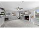 Bright living room with a gray painted brick fireplace, shelving, and a ceiling fan at 4700 Larado Pl, Orlando, FL 32812