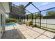 View of the screened-in pool with outdoor seating, grill, and well-maintained stone pavers at 4700 Larado Pl, Orlando, FL 32812