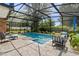 Beautiful screened-in pool area with stone pavers, lush landscaping, and outdoor seating at 4700 Larado Pl, Orlando, FL 32812