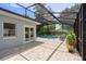 Beautiful screened-in pool area with stone pavers, lush landscaping, and outdoor seating at 4700 Larado Pl, Orlando, FL 32812