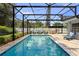View of the screened-in pool with outdoor seating, grill, and well-maintained stone pavers at 4700 Larado Pl, Orlando, FL 32812