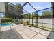 View of the screened-in pool with outdoor seating, grill, and well-maintained stone pavers at 4700 Larado Pl, Orlando, FL 32812