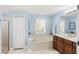 Bright bathroom features a soaking tub, double vanity with wood cabinets and a glass-enclosed shower at 508 Yellow Submarine Ct, Groveland, FL 34736