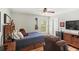 Bedroom featuring a ceiling fan, hardwood floors, and a window with blinds at 508 Yellow Submarine Ct, Groveland, FL 34736