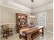 Open dining room features a farmhouse table, wooden hutch, large window and decorative lighting at 508 Yellow Submarine Ct, Groveland, FL 34736