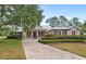 Charming home with a metal roof, manicured landscaping, and a welcoming brick driveway at 508 Yellow Submarine Ct, Groveland, FL 34736