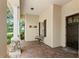 Inviting covered front porch with stone columns, brick pavers, bench, and dark wood front door at 508 Yellow Submarine Ct, Groveland, FL 34736