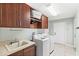 Well-organized laundry room features upper cabinets, utility sink, and modern appliances at 508 Yellow Submarine Ct, Groveland, FL 34736