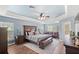 Spacious main bedroom features a sitting area, hardwood floors, ceiling fan and a decorative tray ceiling at 508 Yellow Submarine Ct, Groveland, FL 34736