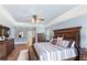 Comfortable main bedroom boasts hardwood floors, a ceiling fan, wood trim and natural light at 508 Yellow Submarine Ct, Groveland, FL 34736