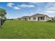 Home backyard showcasing a spacious lawn and exterior view of the rear elevation at 536 Talisi Loop, St Cloud, FL 34771