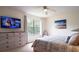 Comfortable bedroom with a large window, flat screen tv, and beach themed art creates a relaxing atmosphere at 626 Verona Ave, Davenport, FL 33897
