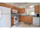 Bright kitchen with wooden cabinets, white appliances, and tiled flooring at 626 Verona Ave, Davenport, FL 33897