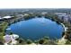 Stunning aerial view showcases a serene lake with a fountain, surrounded by lush greenery and city buildings at 654 Mariposa St, Orlando, FL 32801