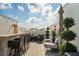 Relaxing rooftop patio with outdoor kitchen, bar, and dining space surrounded by lush greenery at 654 Mariposa St, Orlando, FL 32801