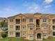 Exterior view of a charming beige building with a staircase and multiple balconies under a beautiful sky at 724 Terrace Ridge Cir # 724, Davenport, FL 33896