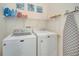 Laundry area showcasing a washer, dryer, iron, ironing board and storage shelf at 724 Terrace Ridge Cir # 724, Davenport, FL 33896