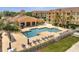 Community pool with lounge chairs, tables, umbrellas, and tropical trees at 724 Terrace Ridge Cir # 724, Davenport, FL 33896